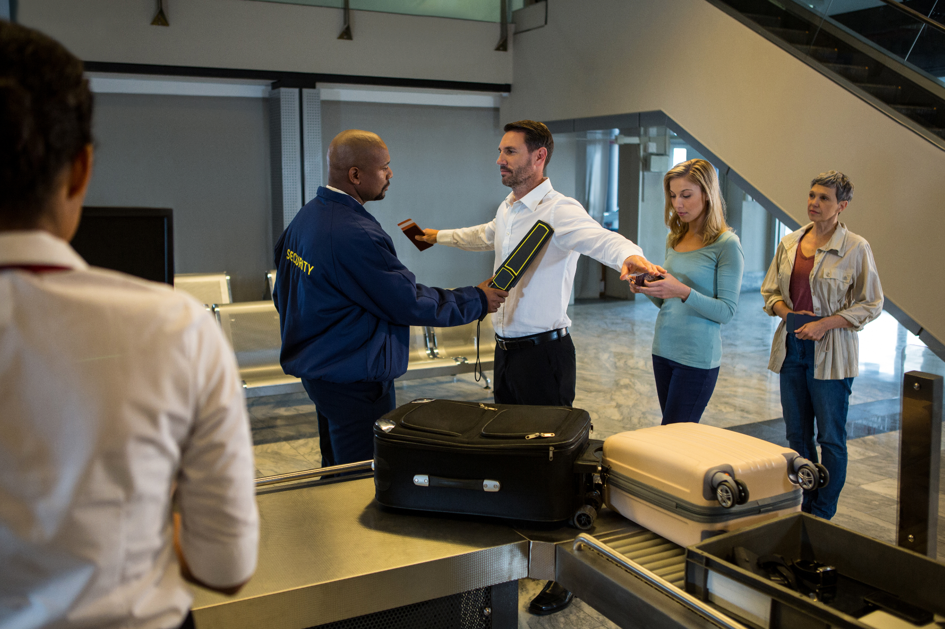 Security guard frisk passengers standing in queue